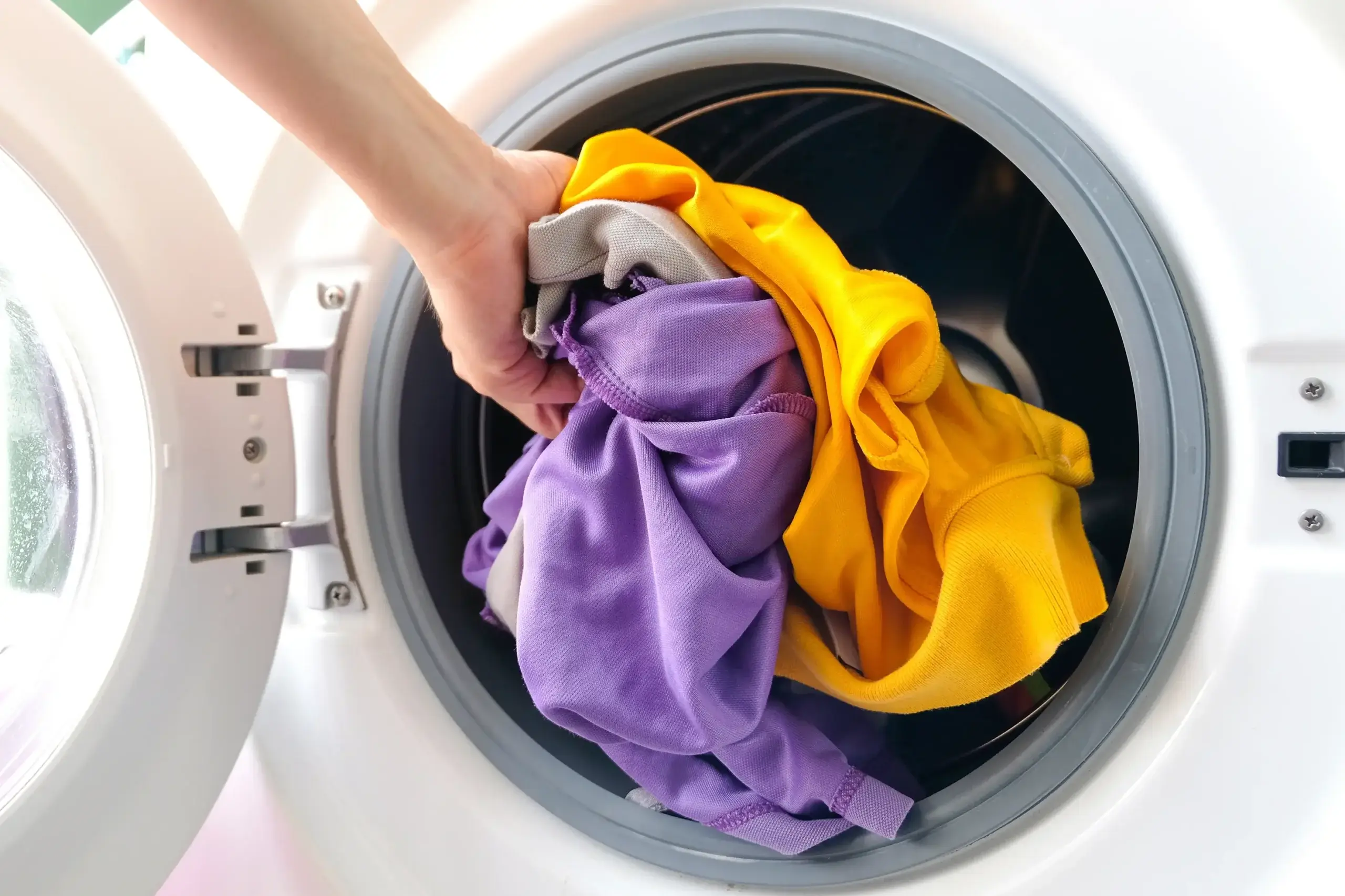 putting clothes in washing machine